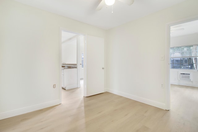 empty room featuring ceiling fan, a wall mounted air conditioner, and light hardwood / wood-style floors