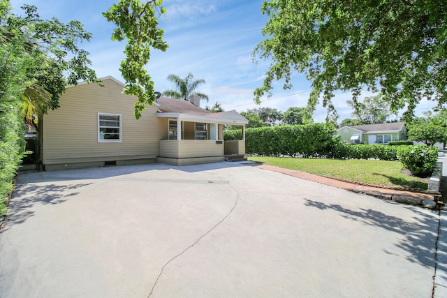 back of house with a lawn and a patio