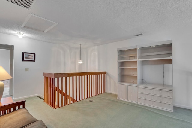 hallway with a textured ceiling and carpet flooring