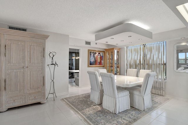 dining area featuring a textured ceiling and light tile patterned floors