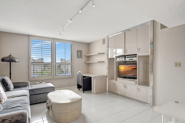 living room featuring a textured ceiling, light tile patterned flooring, and rail lighting