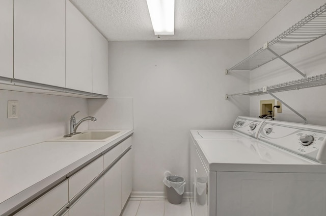 washroom featuring a textured ceiling, cabinets, sink, and washer and dryer