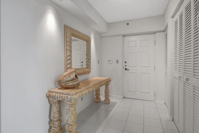 entryway with a textured ceiling and light tile patterned floors