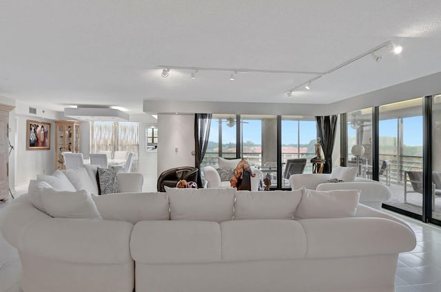 living room with rail lighting and light tile patterned floors