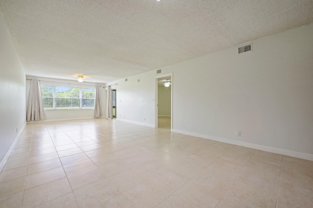 tiled spare room with ceiling fan and a textured ceiling