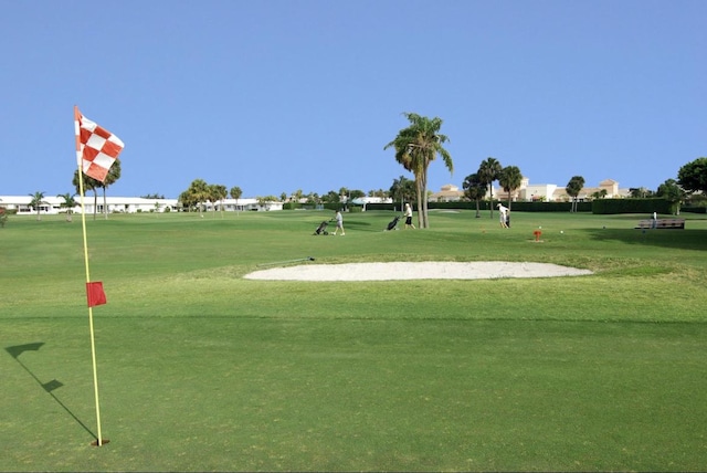 surrounding community with a lawn and golf course view