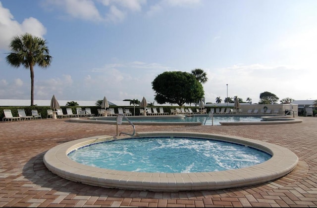 pool featuring a hot tub and a patio area