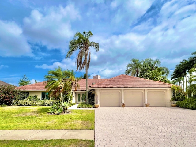 mediterranean / spanish house featuring a front yard and a garage