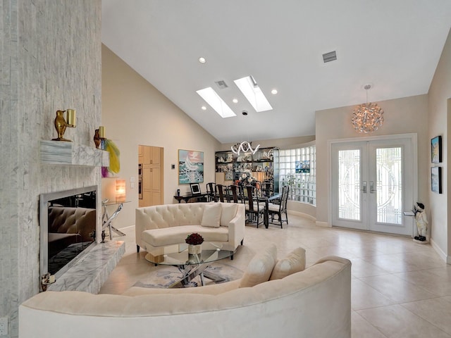 tiled living room featuring a large fireplace, high vaulted ceiling, french doors, and a chandelier