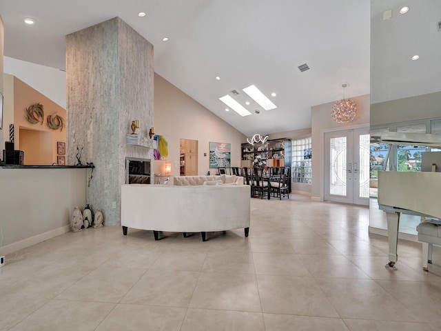 living room with a chandelier, a large fireplace, french doors, high vaulted ceiling, and light tile patterned floors