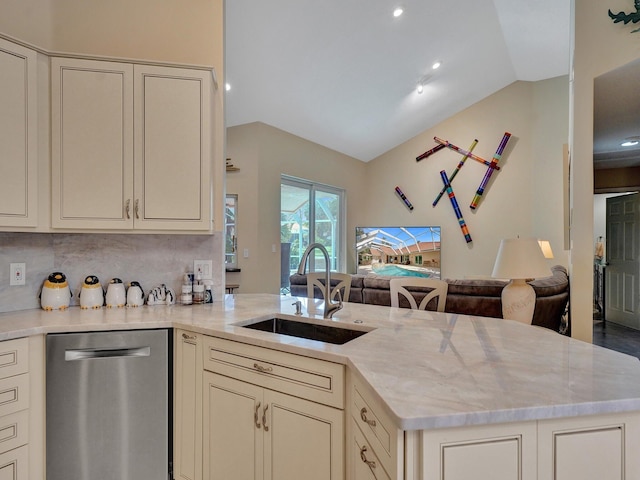 kitchen with cream cabinets, sink, vaulted ceiling, and stainless steel dishwasher