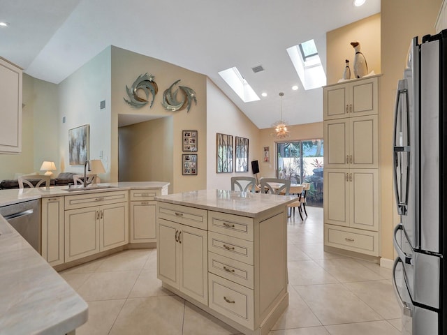 kitchen with stainless steel appliances, hanging light fixtures, and cream cabinets