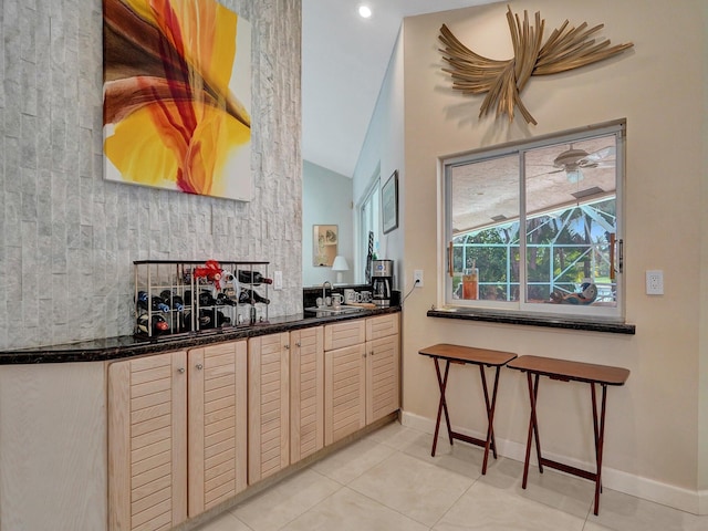 kitchen featuring sink, lofted ceiling, and light tile patterned floors