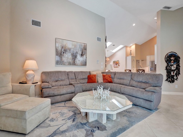 tiled living room with a skylight and high vaulted ceiling