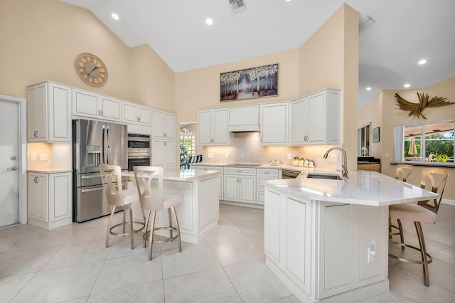 kitchen featuring kitchen peninsula, a kitchen bar, sink, and stainless steel appliances