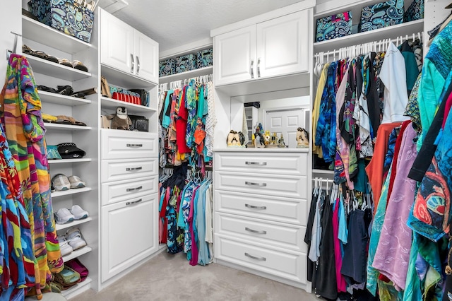 walk in closet featuring light carpet