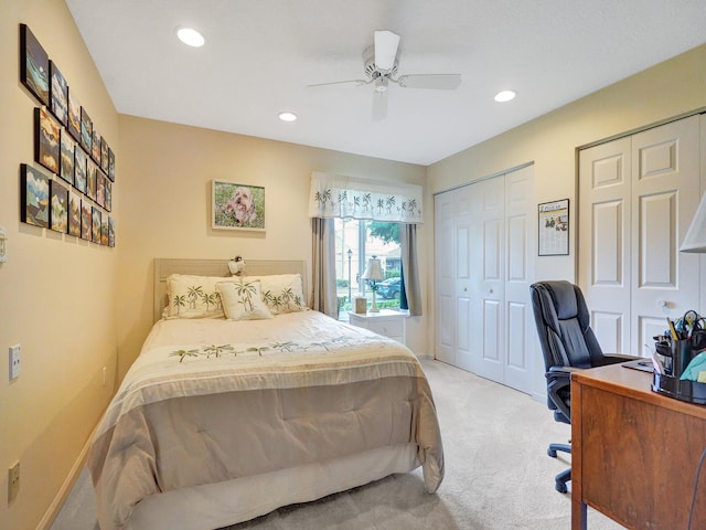 carpeted bedroom with two closets and ceiling fan