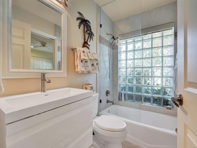 full bathroom with ceiling fan, tiled shower / bath, vanity, and toilet