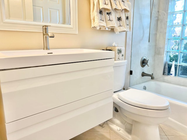 full bathroom with tiled shower / bath, tile patterned floors, vanity, and toilet