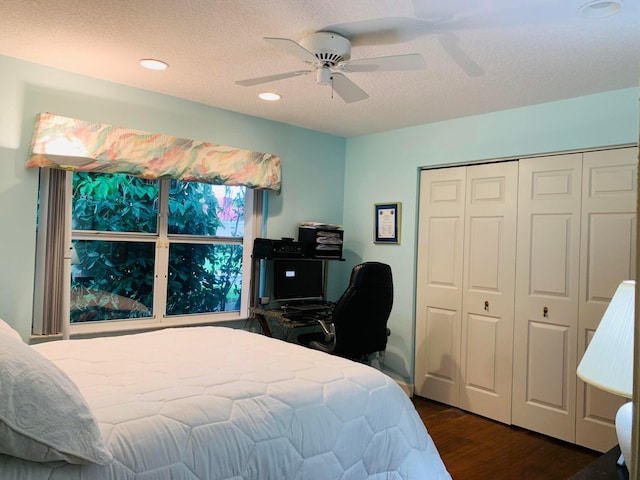 bedroom featuring ceiling fan, a textured ceiling, a closet, and dark hardwood / wood-style flooring