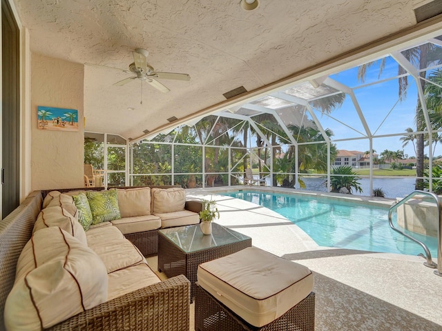 view of pool with ceiling fan, a patio area, an outdoor living space, a water view, and a lanai