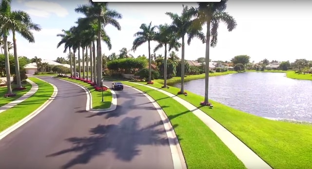 view of community with a water view and a yard