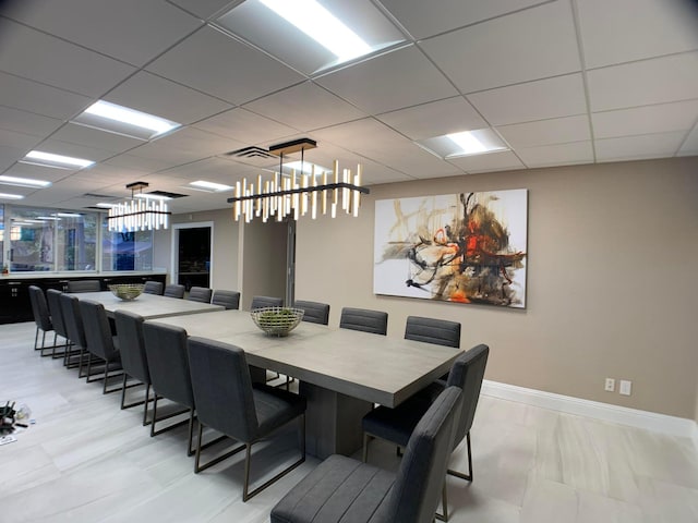 dining room with a drop ceiling and a chandelier