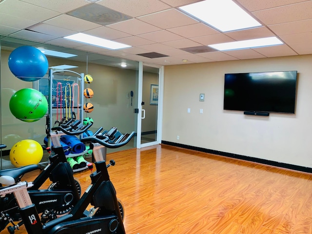 workout area with hardwood / wood-style flooring and a drop ceiling