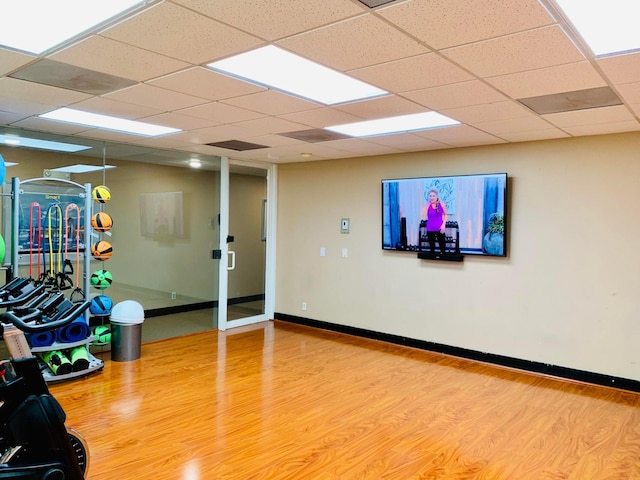 exercise area featuring wood-type flooring and a paneled ceiling