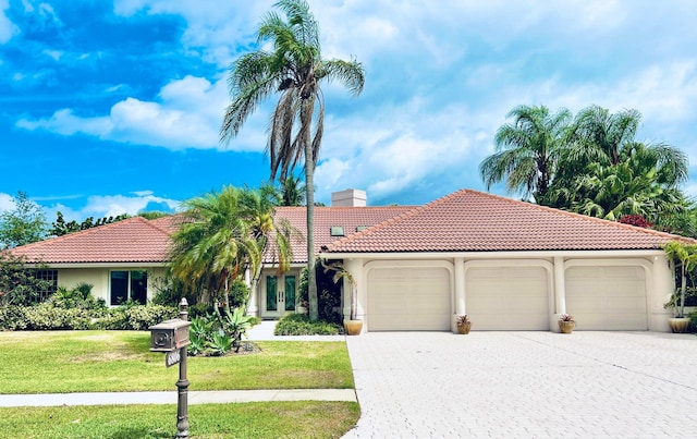 mediterranean / spanish house with a front yard and a garage