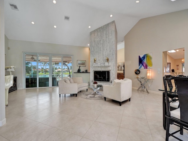 living room with light tile patterned flooring, high vaulted ceiling, and a large fireplace