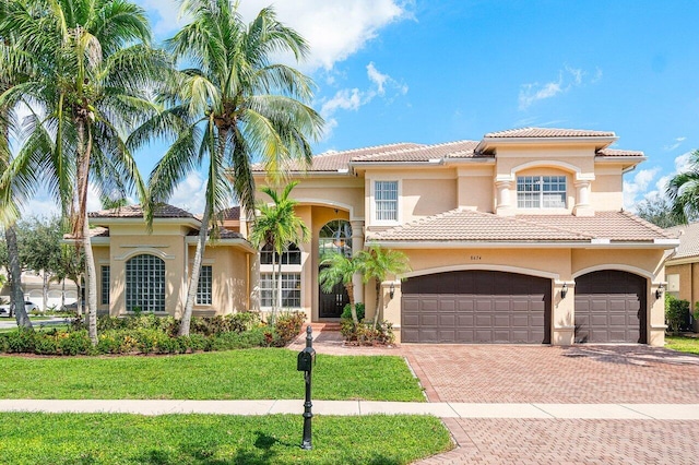 mediterranean / spanish home with a front yard and a garage