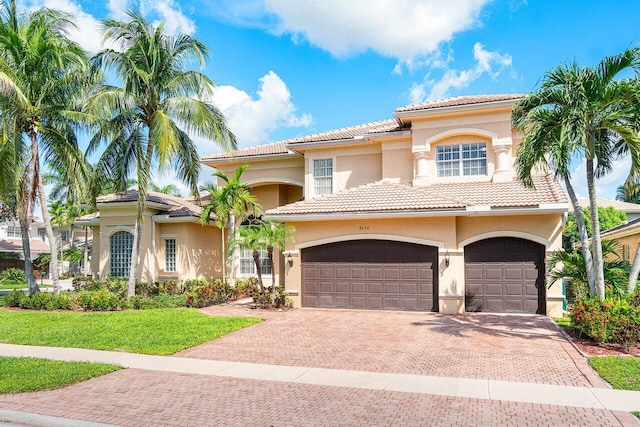 mediterranean / spanish-style home with a garage and a front lawn