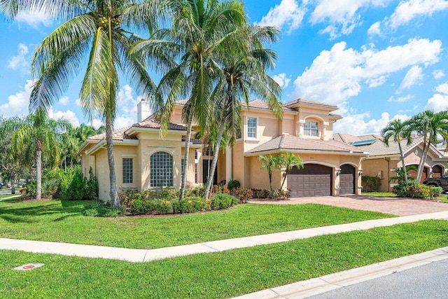 mediterranean / spanish house with a garage and a front yard