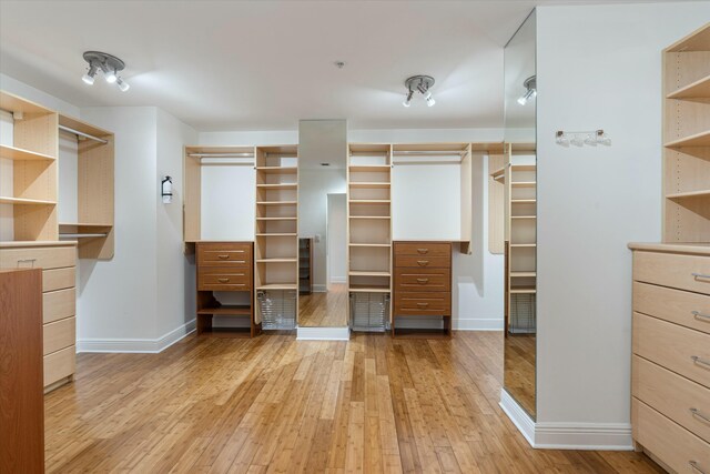 bedroom featuring access to exterior, a textured ceiling, baseboards, and light wood-style floors