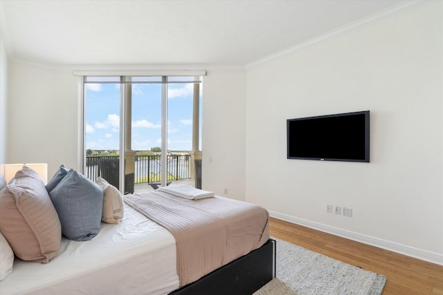 bedroom with ornamental molding, access to outside, baseboards, and wood finished floors