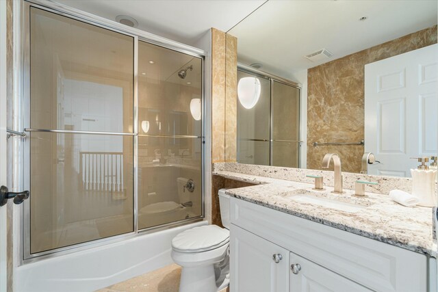 bathroom with visible vents, toilet, enclosed tub / shower combo, tile patterned floors, and vanity