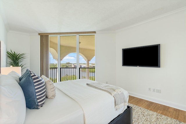 bedroom with crown molding, expansive windows, wood finished floors, access to outside, and baseboards