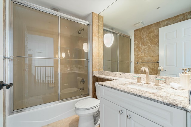 bathroom with toilet, bath / shower combo with glass door, vanity, and visible vents