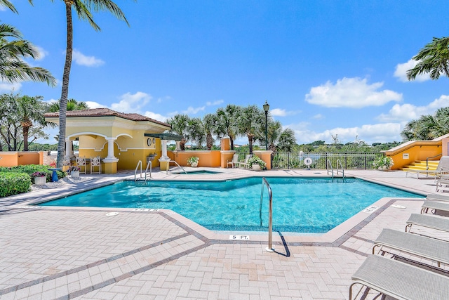 community pool featuring a patio area and fence