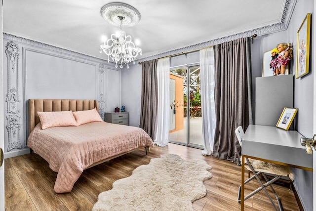 bedroom with crown molding, a chandelier, hardwood / wood-style floors, and access to exterior