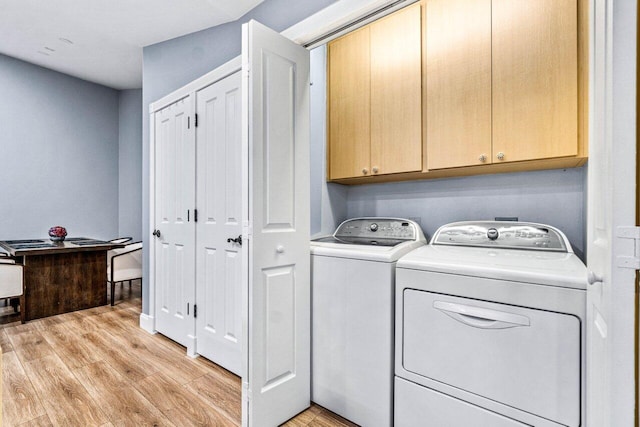 laundry area featuring light hardwood / wood-style flooring, cabinets, and washer and dryer