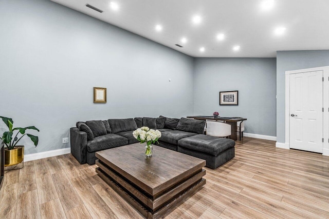 living room featuring light hardwood / wood-style floors and lofted ceiling