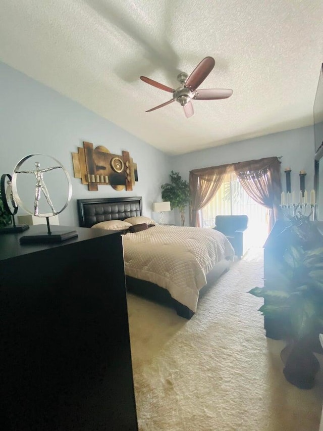 carpeted bedroom with ceiling fan and a textured ceiling