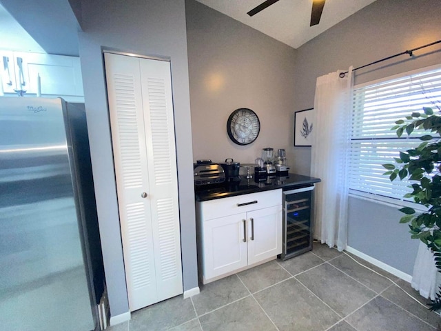 bar featuring beverage cooler, light tile patterned floors, white cabinets, stainless steel refrigerator, and ceiling fan