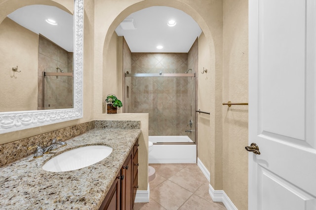 full bathroom featuring bath / shower combo with glass door, tile patterned flooring, vanity, and toilet