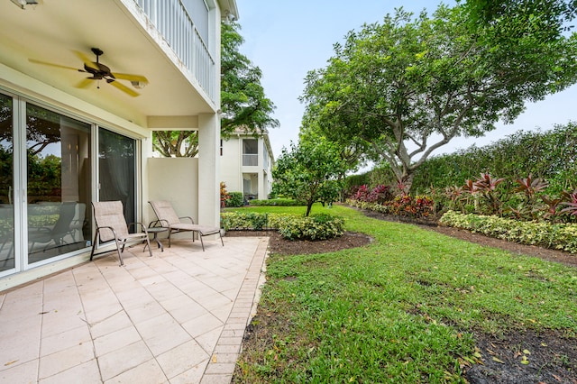 view of yard featuring ceiling fan, a balcony, and a patio