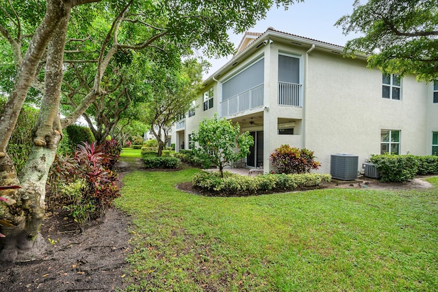 6189 Island Walk Unit A, Boca Raton, FL 33496 - view of side of home featuring central AC unit, stucco siding, and a yard