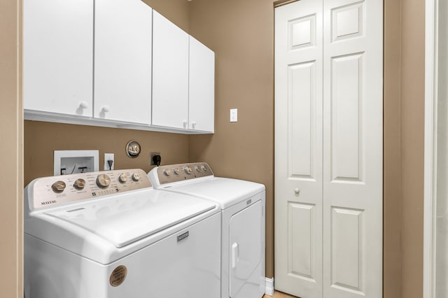 laundry area with washing machine and dryer and cabinets