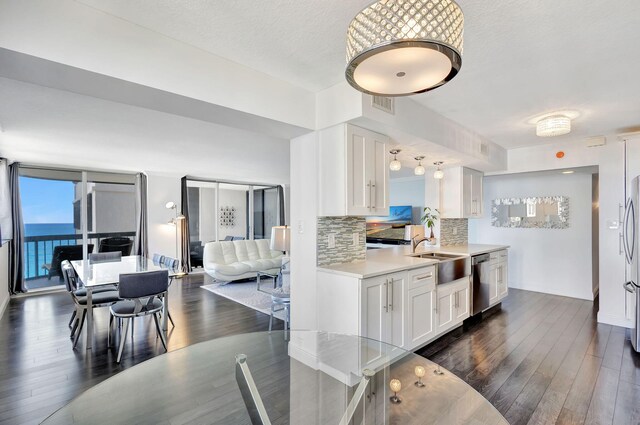 kitchen featuring white cabinetry, stainless steel dishwasher, and dark hardwood / wood-style floors